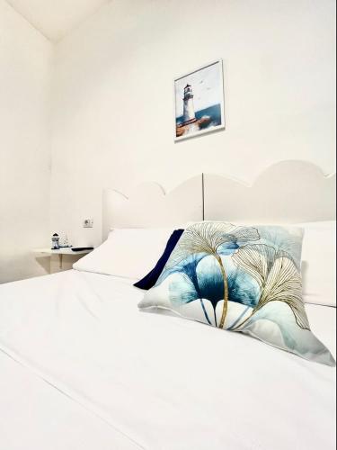 a white bedroom with a bed with a white headboard at Meridiana in Ischia