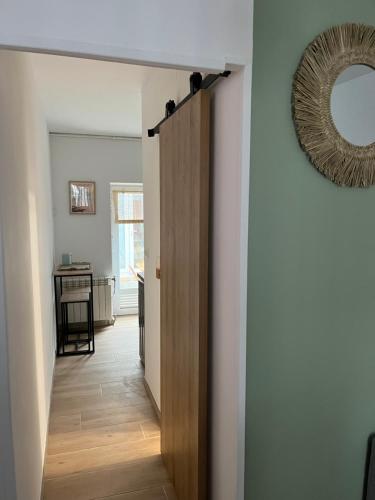 um corredor com uma porta e um espelho na parede em Appartement Hendaye em Urrugne