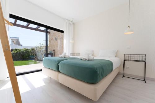 a bedroom with a bed and a large window at Villa Hobie Cat in Sagres