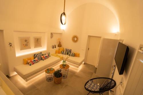 a living room with a couch and a table at Acrus Villa Santorini with Heated pool in Karterados