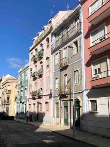 une rangée de bâtiments dans une rue d'une ville dans l'établissement Angels Homes-n27, 2ºfloor - Bairro Tipico, Centro Lisboa, à Lisbonne
