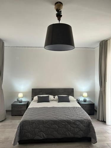 a bedroom with a large bed and a black lamp at Alloggio Pulcinella in Acerra