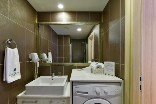 a bathroom with a sink and a washing machine at La Flora House Hotel in Kocaeli