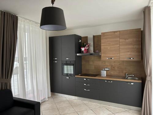 a kitchen with black cabinets and a sink at Alloggio Pulcinella in Acerra