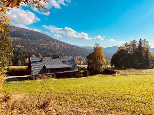 a house in the middle of a grassy field at Chata Boubín in Kubova Huť