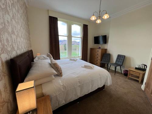 um quarto com uma cama grande e uma janela em Brundholme em Keswick