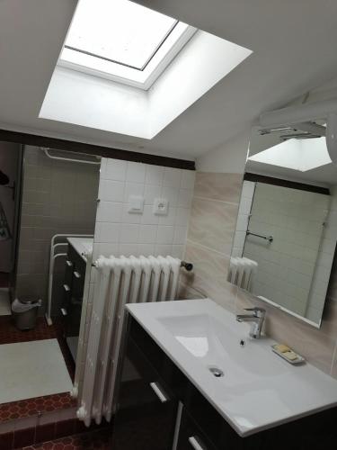 une salle de bain avec un lavabo blanc et une lucarne dans l'établissement Lou mas suzoun, à Ucel