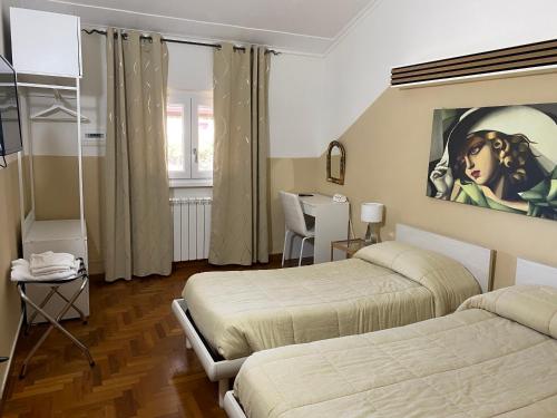 フラスカーティにあるVillaGiò B&Bのベッドルーム1室(ベッド2台付)が備わります。壁には絵画が飾られています。