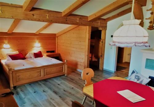 a bedroom with a bed and a table in a room at Hotel Gut Kramerhof in Kirchdorf in Tirol