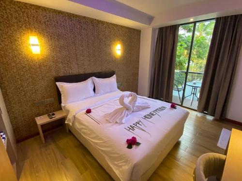 a hotel room with a bed with flowers on it at Ari Grand Hotel & Spa in Dhangethi