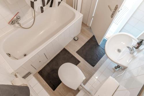 ein Badezimmer mit einer weißen Badewanne, einem WC und einem Waschbecken in der Unterkunft City-Center App ZENTRAL, 24-7 Check-in in Kiel