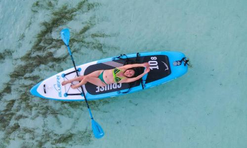 a man is laying on a kayak with a paddle at Ari Grand Hotel & Spa in Dhangethi
