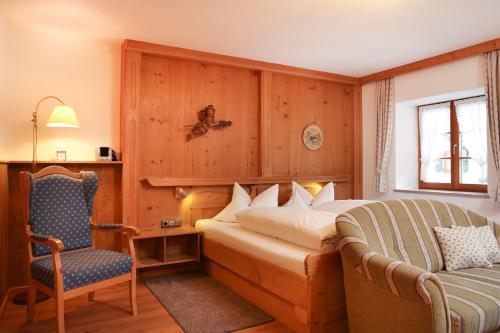 una camera d'albergo con letto e sedia di Beim Gschdoaga a Mittenwald