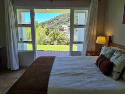 a bedroom with a large bed and a large window at Villa Arroyo, Estuary Estate, Port Edward in Port Edward