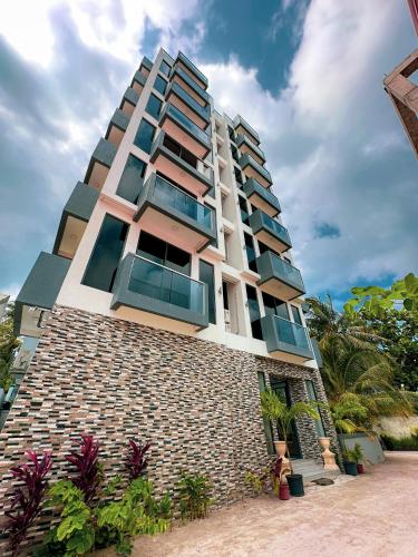 a tall building with windows on the side of it at Ari Grand Hotel & Spa in Dhangethi