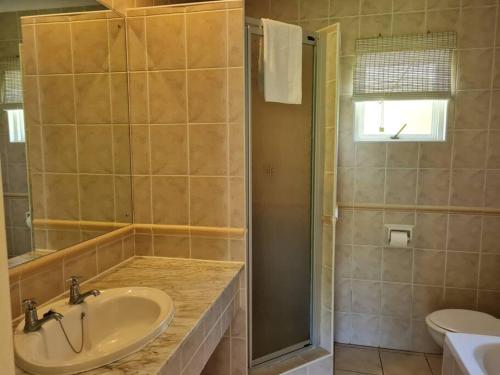 La salle de bains est pourvue d'un lavabo et d'une douche. dans l'établissement Villa Arroyo, Estuary Estate, Port Edward, à Port Edward
