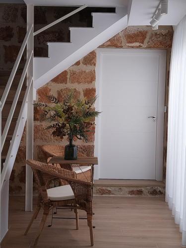un pasillo con una puerta blanca y una mesa con una planta en Alojamientos rurales Arbonaida, en Baños de la Encina