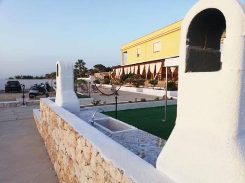 a stone retaining wall with a sink in front of a building at CASE VACANZE I QUATTROVENTI in Lampedusa