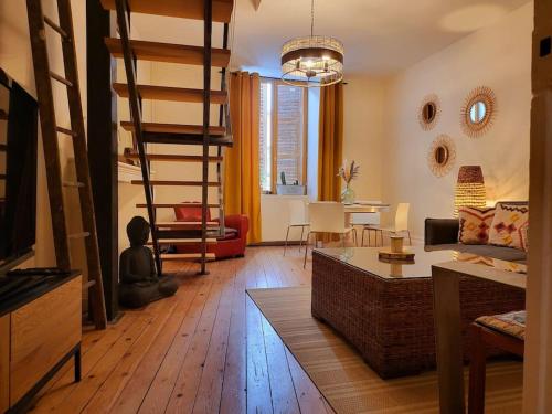 un salon avec un parquet et un escalier en colimaçon dans l'établissement Duplex bohème chic, à Gannat