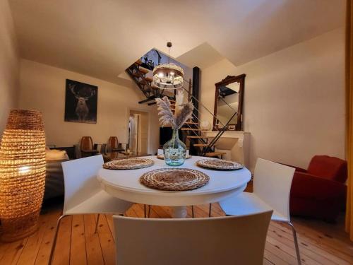 ein Wohnzimmer mit einem weißen Tisch und Stühlen in der Unterkunft Duplex bohème chic in Gannat