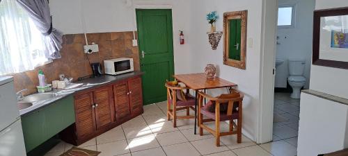 cocina con mesa y puerta verde en Purple House B&B Smithfield en Smithfield