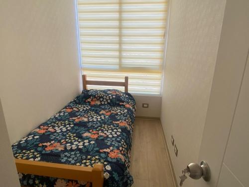 Un dormitorio pequeño con una cama y una ventana. en departamento nuevo amoblado sin uso, en Viña del Mar