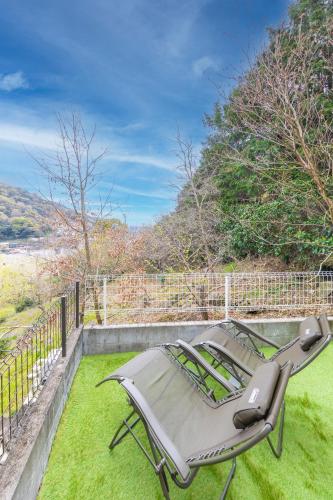 a chair sitting on the grass in a yard at LINKAGE STAY HAKONE YUMOTO in Hakone
