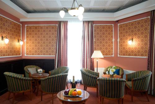 a hotel room with chairs and a table with fruit at Hotel Villa Lauretta in Karlovy Vary