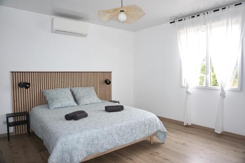- une chambre blanche avec un lit et un ventilateur dans l'établissement Maison à 300m de la plage, Classée 3 étoiles - Le Crotoy, au Crotoy
