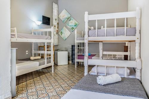 a room with four bunk beds and a rug at Vilarejo do Perequê in Ilhabela