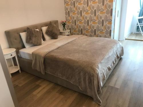Un dormitorio con una cama grande con suelo de madera. en Studio Lotus, en Bucarest