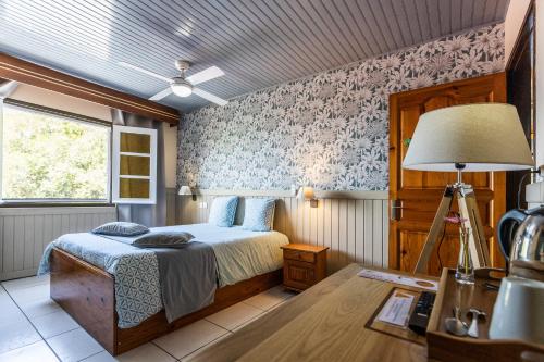 サン・ジョゼフにあるAuberge Desprairiesのベッドルーム1室(ベッド1台、ランプ付きテーブル付)