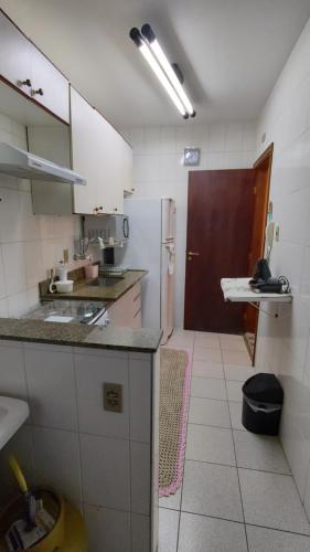een keuken met een wastafel en een bruine deur bij Enseada Guarujá Ap214 in Guarujá