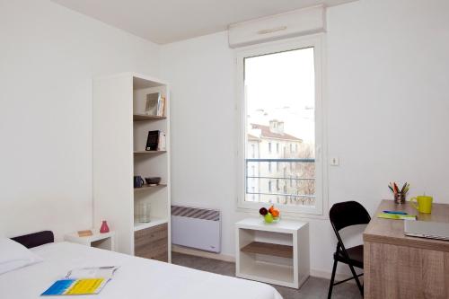 a bedroom with a bed and a desk and a window at Séjours & Affaires Annecy Le Pont Neuf in Annecy