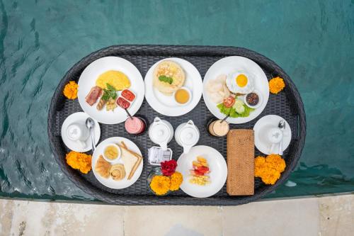 a tray of food with eggs and other foods on it at Uma Sebatu Villa Ubud in Tegalalang