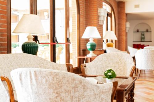 a room with chairs and a table with two lamps at Fattoria La Principina Hotel & Congress in Principina Terra