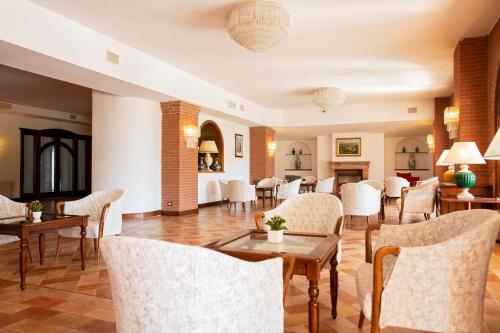 a dining room with chairs and tables and a room at Fattoria La Principina Hotel & Congress in Principina Terra