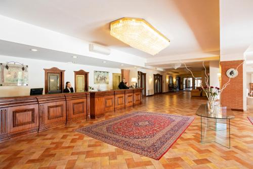 a lobby with a reception desk and a mirror at Fattoria La Principina Hotel & Congress in Principina Terra