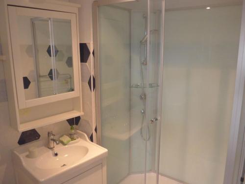 une salle de bain blanche avec une douche et un lavabo dans l'établissement Appartement cosy en centre-ville, proche plage, pour 4 pers. avec cour privée et tout confort - FR-1-418-68, au Palais