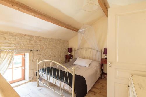 1 dormitorio con cama y ventana en La Maison du Puits, son gîte, et sa piscine, en Villeneuve-la-Comtesse