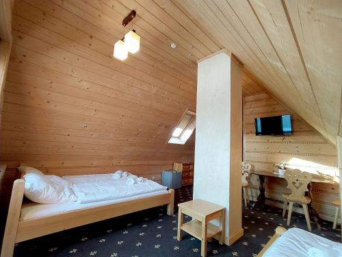 a bedroom with a bed in a wooden room at Chochołowskie Zacisze przy Termach - Apartamenty i Pokoje in Chochołów