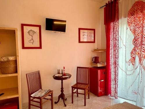 een kamer met een tafel en twee stoelen en een televisie bij Casa del Palombaro in Le Grazie