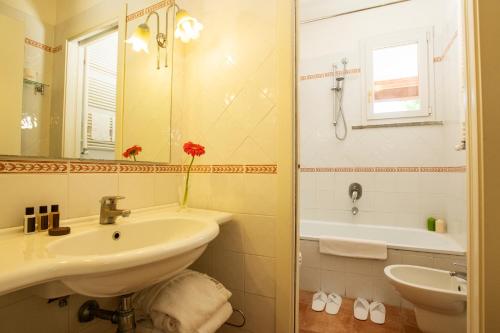 a bathroom with a sink and a bath tub at Fattoria La Principina Hotel & Congress in Principina Terra