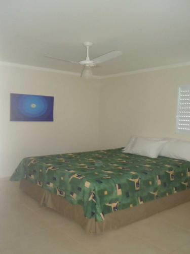 a bed in a room with a ceiling at Pousada Clariô in Bertioga