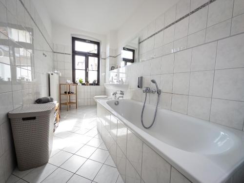 a white bathroom with a tub and a sink at Moderne 3Zimmer Wohnung mit Netflix und Balkon in Leipzig