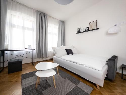 a white living room with a white bed and a table at Moderne 3Zimmer Wohnung mit Netflix und Balkon in Leipzig