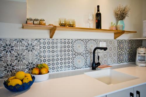 a kitchen counter with a sink and a bowl of fruit at lotus beach house in H̱adera