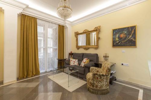 uma sala de estar com um sofá e uma cadeira em Tu Casa En Granada ideal para tu familia em Granada