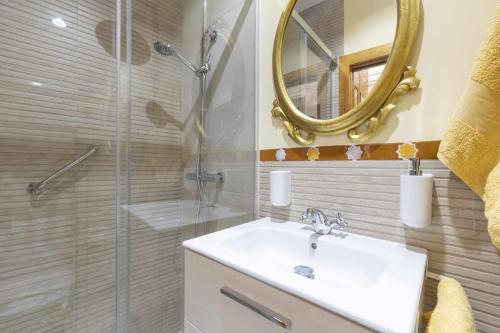 a bathroom with a sink and a shower with a mirror at Tu Casa En Granada ideal para tu familia in Granada