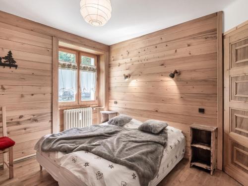 ムジェーヴにあるAppartement Megève, 3 pièces, 4 personnes - FR-1-453-47の木製の壁と大型ベッドが備わるベッドルーム1室が備わります。